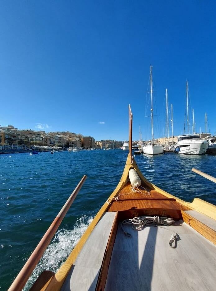 Boat crossing Grand Harbour with views of Valletta skyline